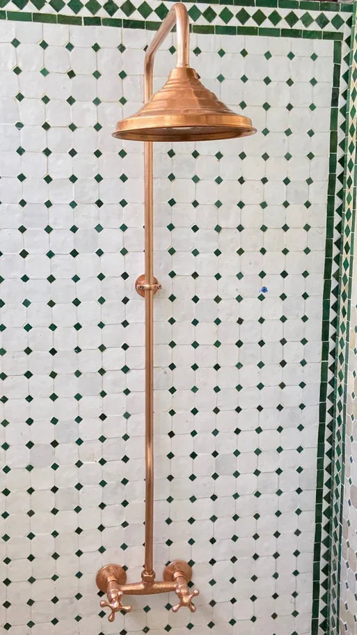 Bathroom with copper fixtures and green and white tiled walls