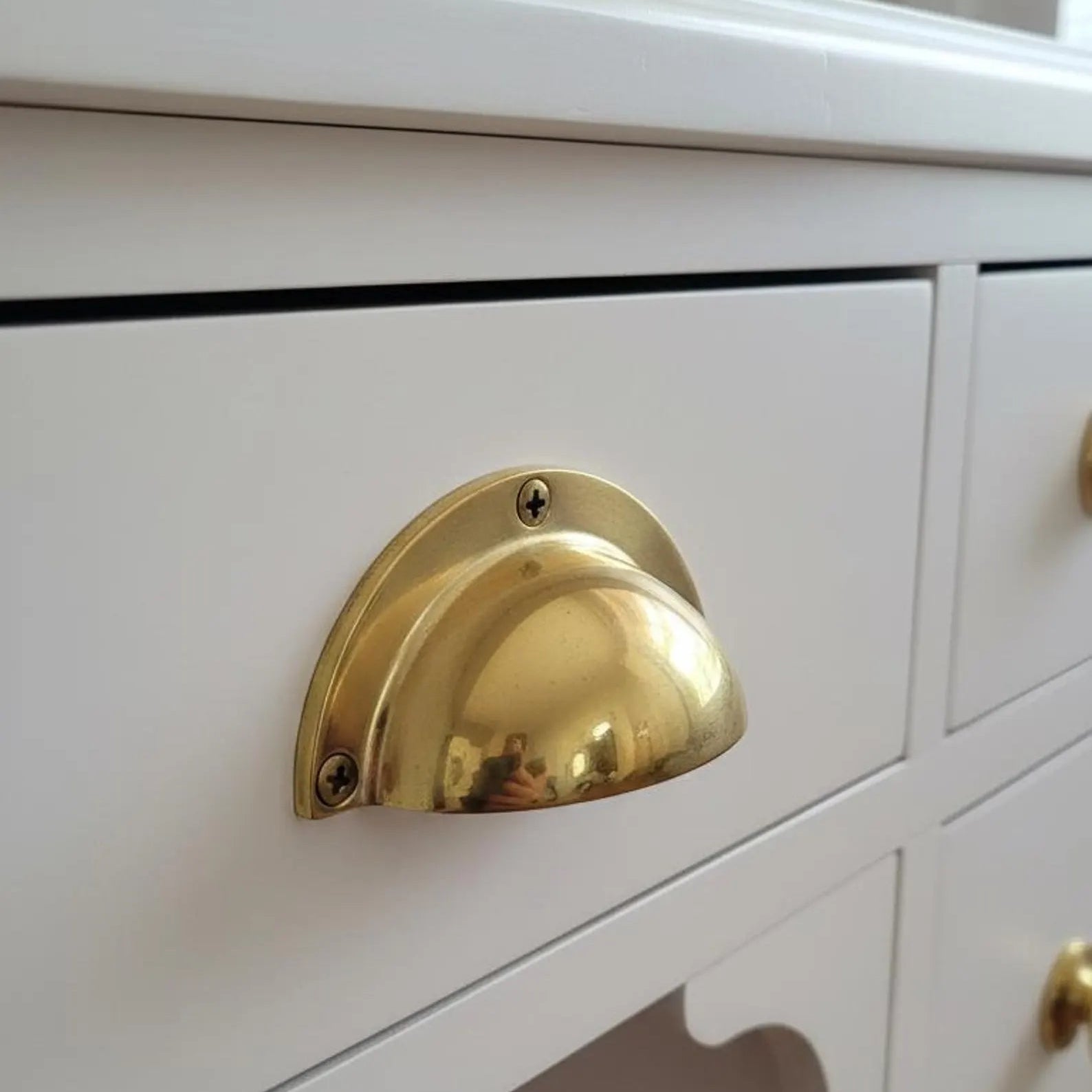 Close-up of a white dresser with a gold handle