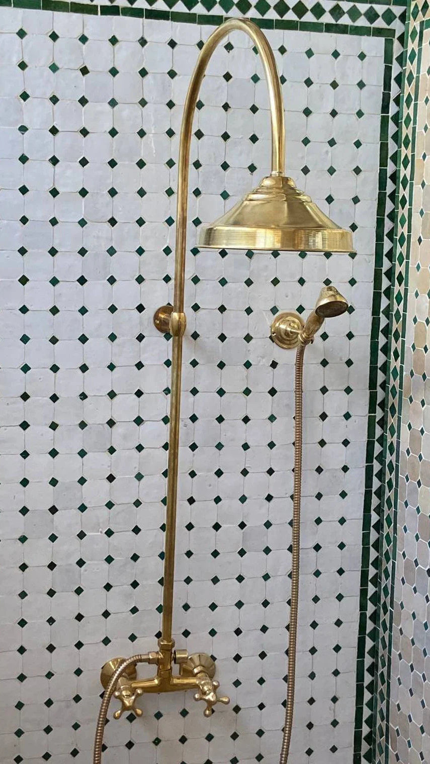 Gold shower head and fixtures against a tiled wall with a geometric pattern.