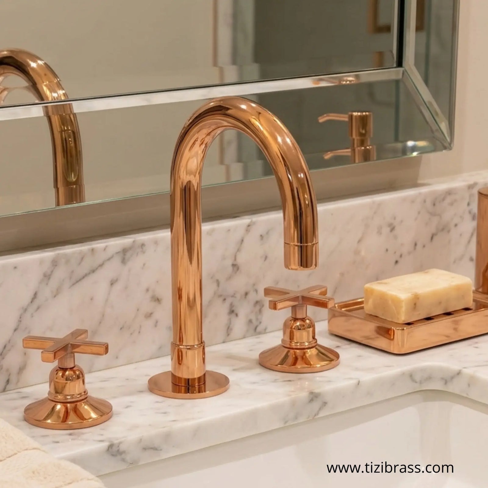 Unlacquered rose gold brass bathroom faucet set with cross handles and soap dish on a white marble vanity countertop.