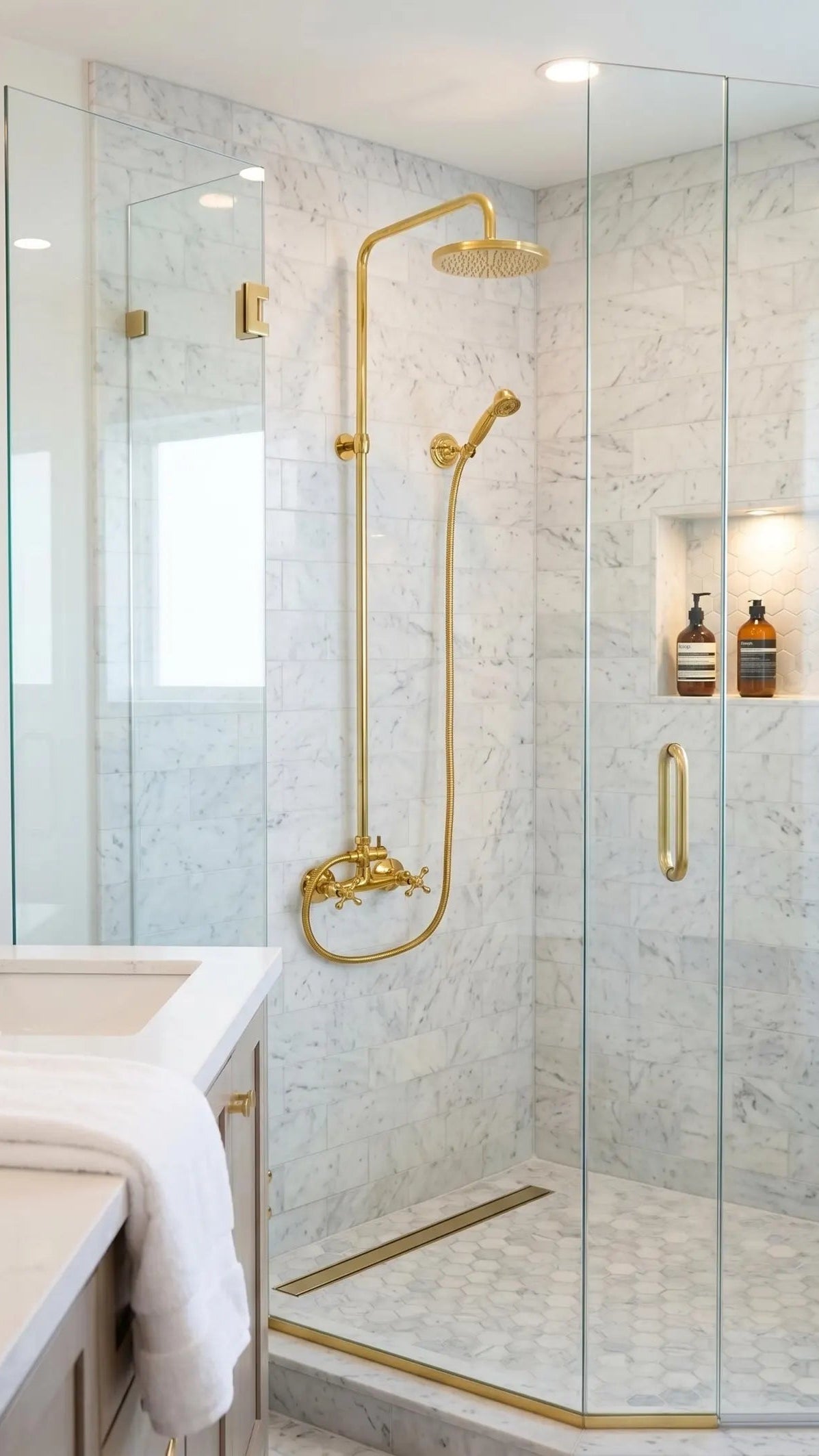 Modern bathroom with glass shower enclosure and gold fixtures
