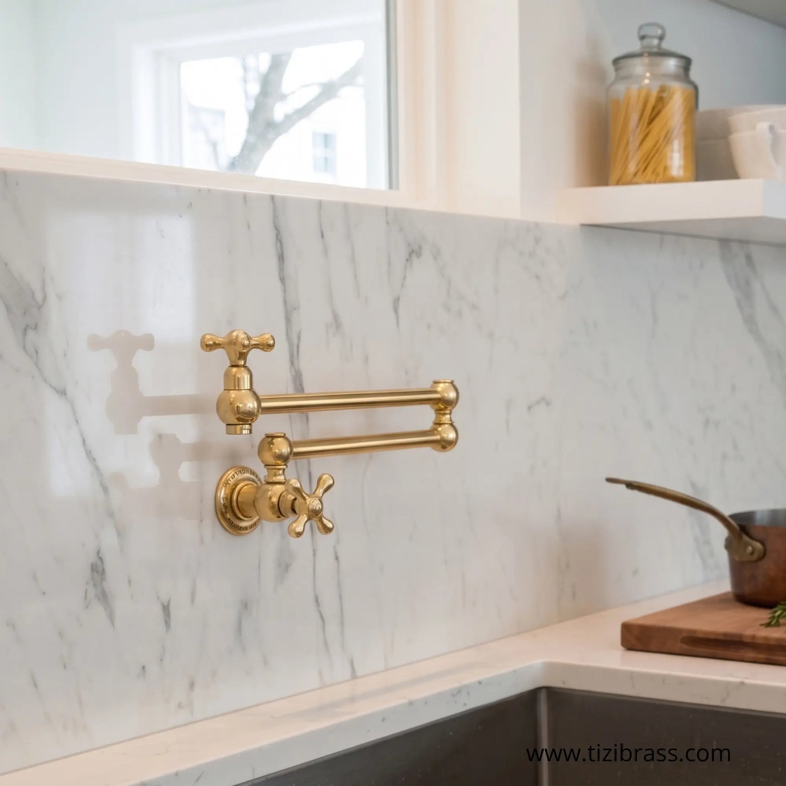 Wall-mounted unlacquered brass pot filler faucet installed over a white marble backsplash in a modern luxury kitchen.