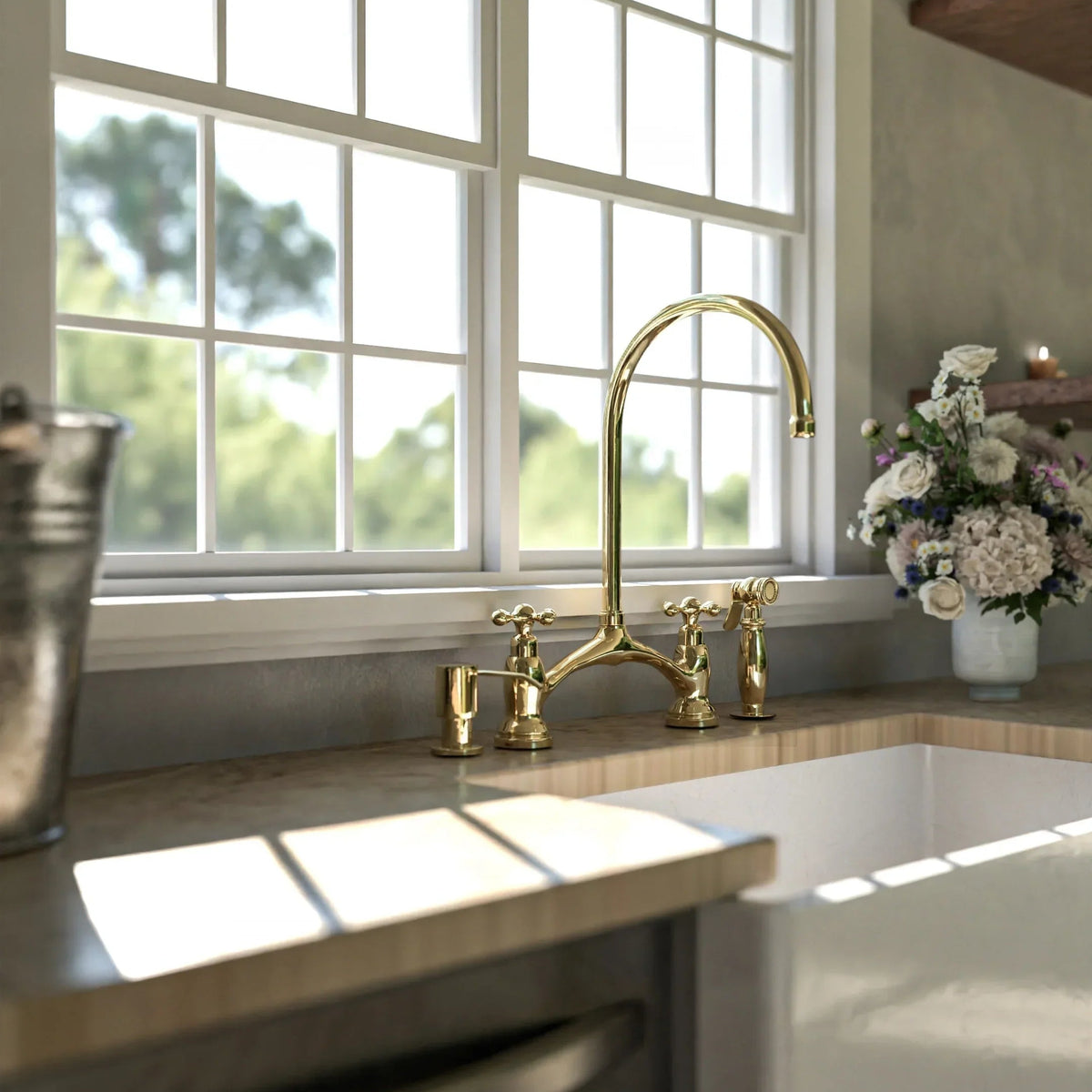 Kitchen sink with gold faucet and window in the background